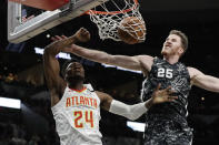 Atlanta Hawks forward Bruno Fernando (24) scores past San Antonio Spurs center Jakob Poeltl (25) during the first half of an NBA basketball game in San Antonio, Friday, Jan. 17, 2020. (AP Photo/Eric Gay)