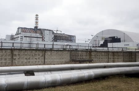 A general view shows a containment shelter for the damaged fourth reactor (L) and the New Safe Confinement (NSC) structure (R) at the Chernobyl Nuclear Power Plant, Ukraine, March 23, 2016. REUTERS/Gleb Garanich