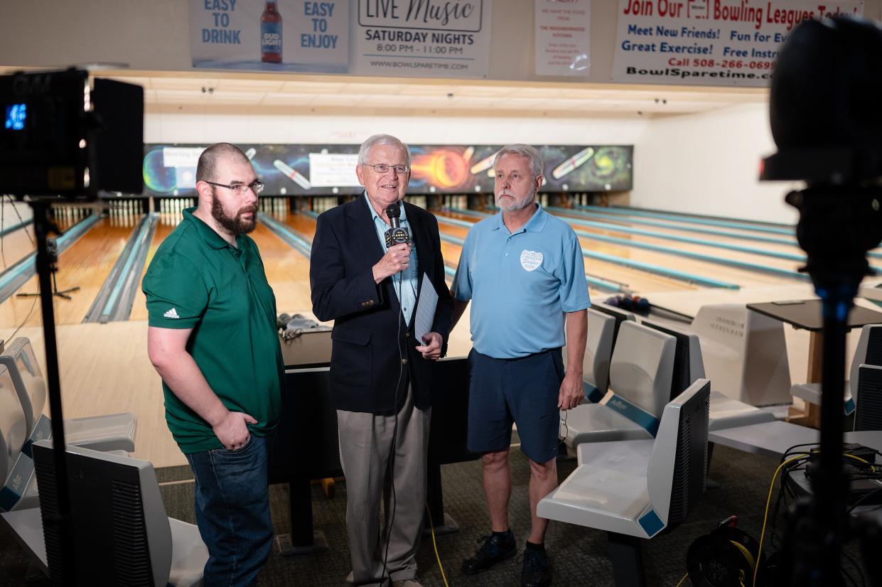 Pete Royce, center, interviews Danny Finn, left, and Rick Kamrowski, right, during "Bowling for Scholars," a TV program that raises money for college students hosted at Sparetime Recreation in Whitinsville on Thursday.