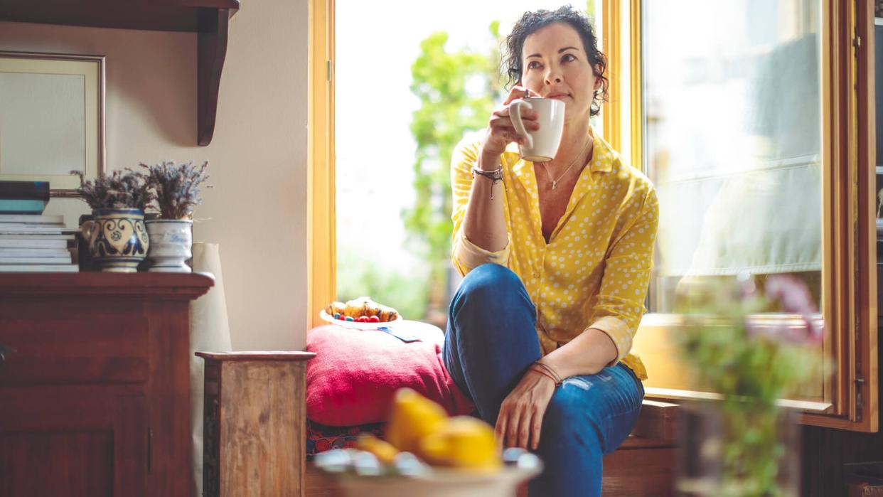 Mature woman is having the morning coffee at home.