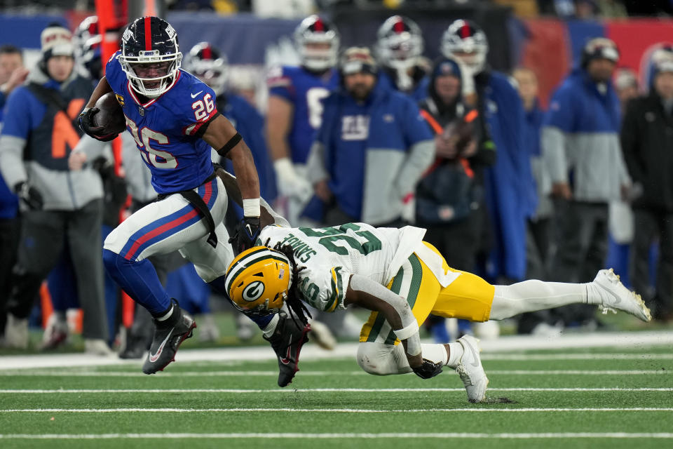 New York Giants running back Saquon Barkley (26) avoids a tackle by Green Bay Packers safety Darnell Savage (26) during the fourth quarter of an NFL football game, Monday, Dec. 11, 2023, in East Rutherford, N.J. (AP Photo/Seth Wenig)