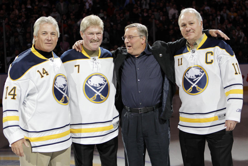 FILE - In this Feb. 23, 2011 file photo, Buffalo Sabres new owner Terry Pegula, second from right, poses with former Sabres players Rene Robert (14), Rick Martin (7) and Gilbert Perreault (11) before an NHL hockey game against the Atlanta Thrashers in Buffalo, N.Y. Rene Robert, a member of the Buffalo Sabres' famed "French Connection Line," died Tuesday, June 22, 2021 at a Florida hospital a few days after suffering a heart attack. He was 72. (AP Photo/David Duprey, File)