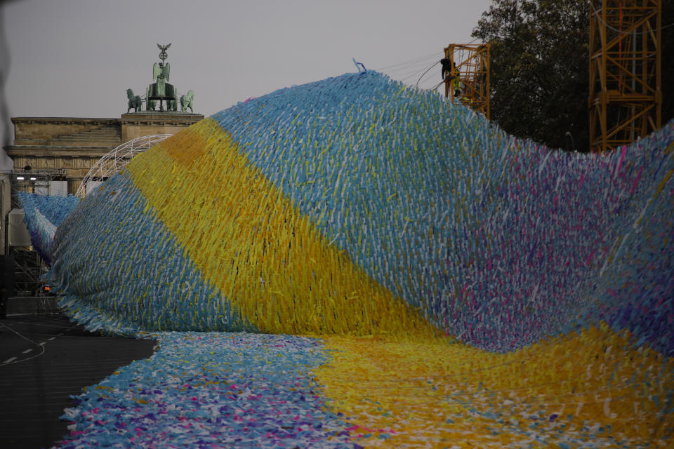 The skynet artwork 'Visions In Motion' is set to overhang the 'Strasse des 17. Juni' (Street of June 17) boulevard in front of the Brandenburg Gate in Berlin, Germany, Friday, Nov. 1, 2019. The art work by Patrick Shearn was made with about 100.000 streamers with written messages and is part of the celebrations marking the 30th anniversary of the fall of the Berlin Wall on Nov 9, 2019. (AP Photo/Markus Schreiber)