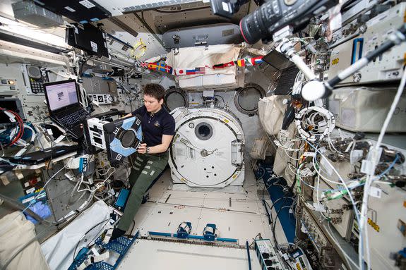 Anne McClain checks Astrobee.