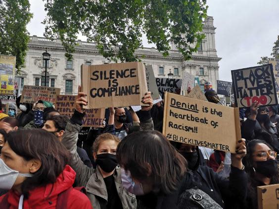 Placards carried by demonstrators referenced the coronavirus crisis and called for justice (Gemma Fox/The Independent)