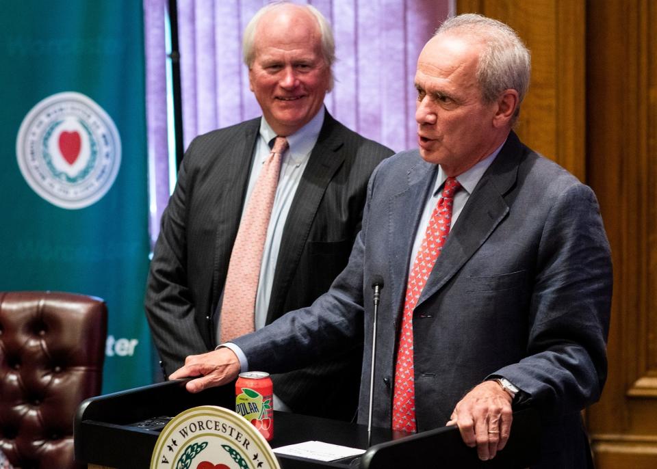 Larry Lucchino presents a soda to Polar Beverages CEO Ralph Crowley Jr. as he announces the relocation of the of the Pawtucket Red Sox to Worcester, and to Polar Park, at City Hall in August 2018.
