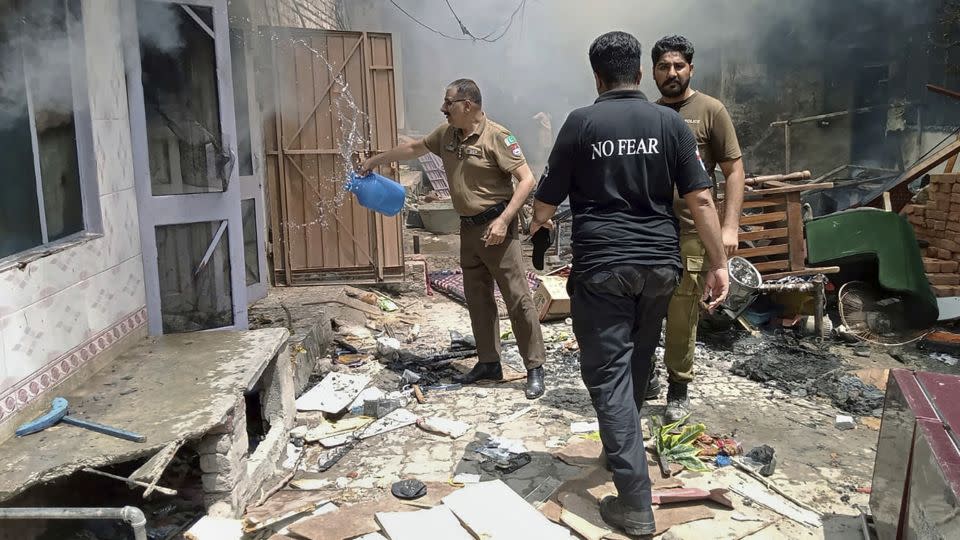 Police inspect a house that was set on fire in Jaranwala in Punjab. Pakistan's caretaker PM called the attacks in the Christian neighborhood "illegal and unconstitutional." - District Police Office/AP