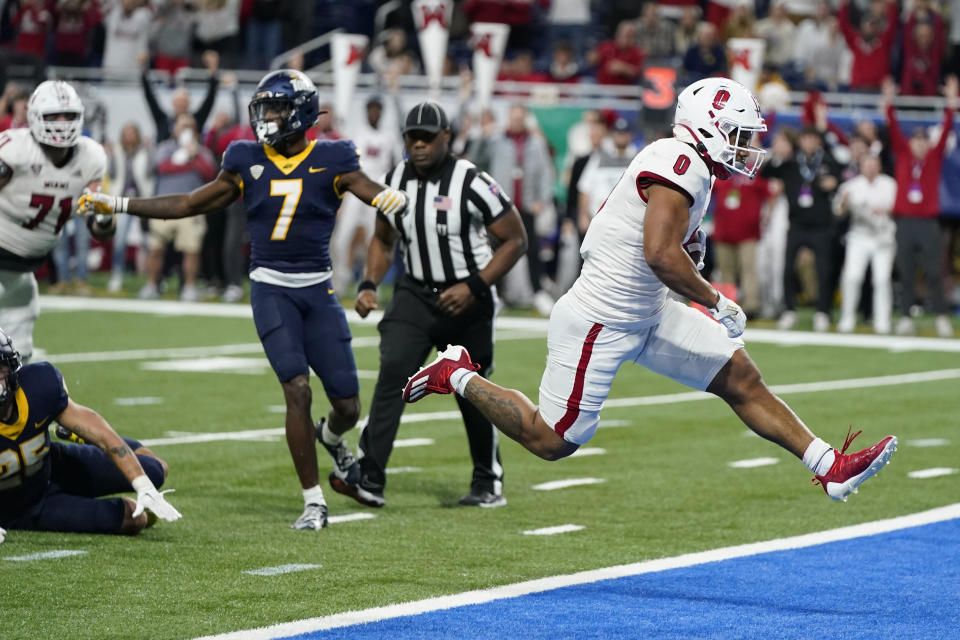 Miami (Ohio) running back Rashad Amos (0) breaks through the Toledo defense for a 10-yard rushing touchdown during the second half of the Mid-American Conference championship NCAA college football game, Saturday, Dec. 2, 2023, in Detroit. (AP Photo/Carlos Osorio)