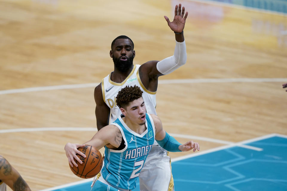 Charlotte Hornets guard LaMelo Ball drives around Dallas Mavericks forward Tim Hardaway Jr. during the first half of an NBA basketball game in Charlotte, N.C., Wednesday, Jan. 13, 2021. (AP Photo/Chris Carlson)