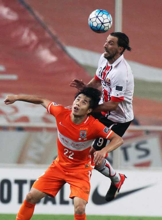 Hao Junmin of Shandong Luneng (L) fights for the ball with Dejan Damjanovic of FC Seoul during their AFC Champions League match in Jinan, China's Shandong province, on September 14, 2016