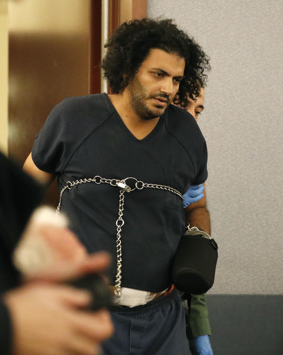 Mohamed Abdalla Mahmoud is escorted into court Tuesday, Aug. 21, 2018, in Las Vegas. Mahmoud was wounded by police after allegedly opening fire with a handgun in a Las Vegas clothing store. (AP Photo/John Locher)