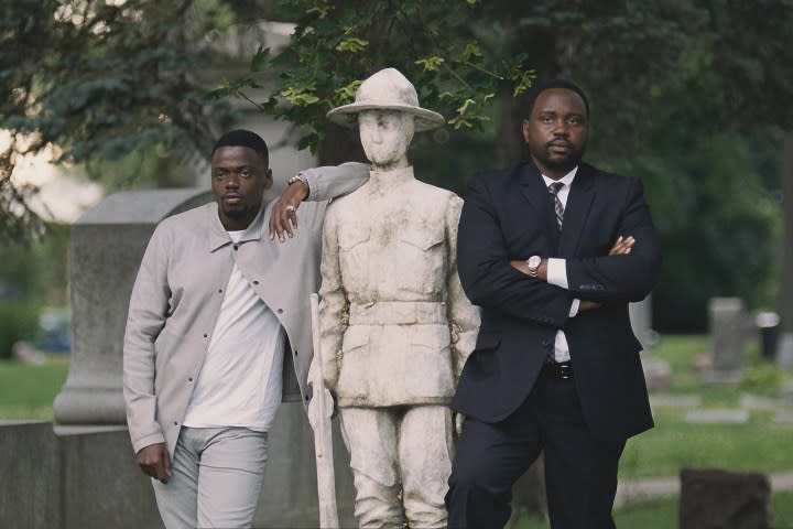 Daniel Kaluuya and Brian Tyree Henry lean against a statue in Widows.