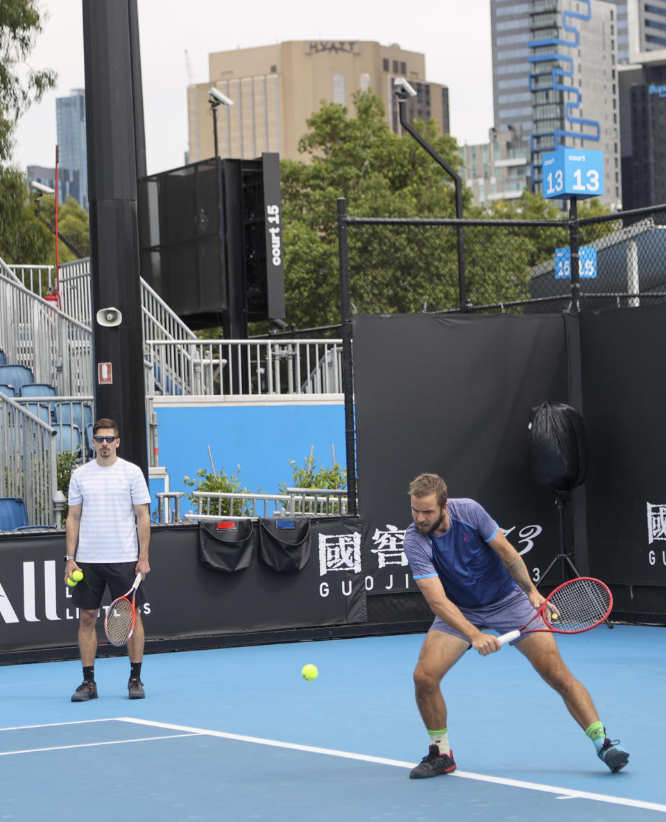 A player practices on an outside court at Melbourne Park, venue for the Australian Open tennis championships in Melbourne, Australia, Thursday, Feb. 4, 2021. All competition at six Australian Open tuneup events scheduled for Thursday was called off after a worker at one of the tournaments' Melbourne quarantine hotels tested positive for COVID-19.(AP Photo/Hamish Blair)