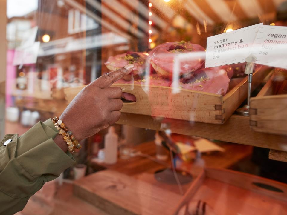 Woman pointing at doughnut in bakery