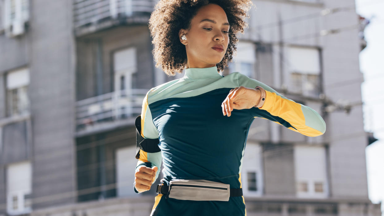  Woman checking sports watch while running. 