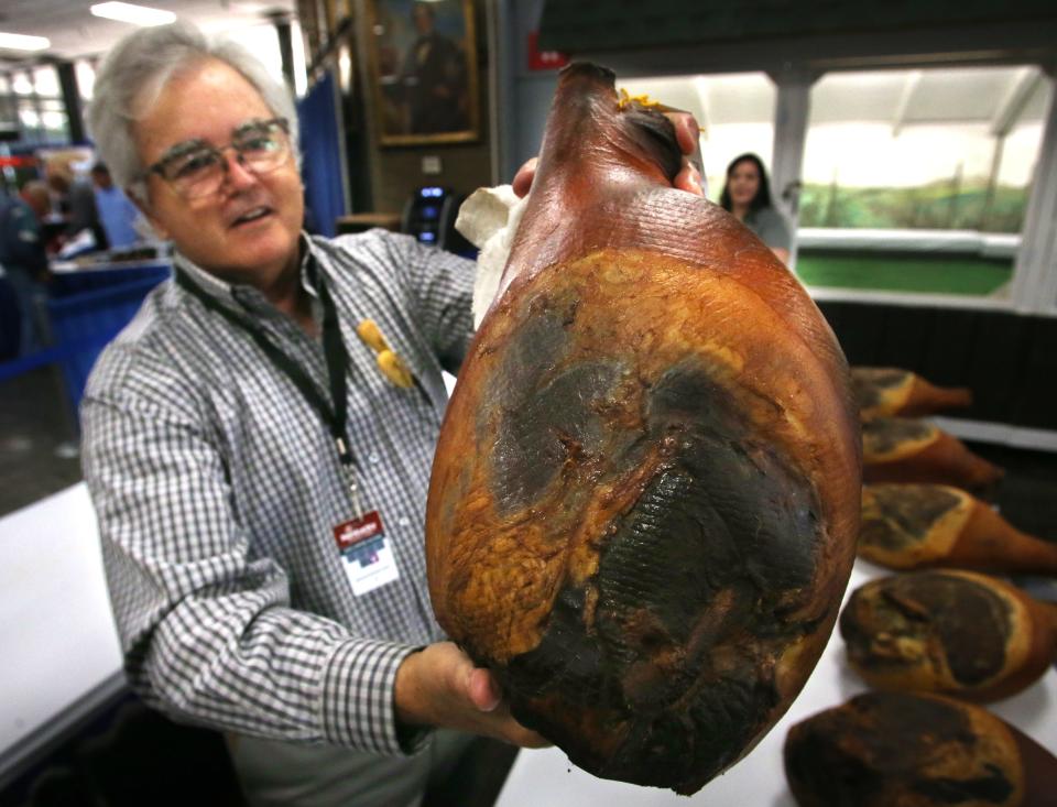Bob Woods, holds up the blue ribbon winning ham from Broadbent Country Hams, that will be auctioned off for charity next Thursday at the Kentucky State Fair. Aug. 18, 2022
