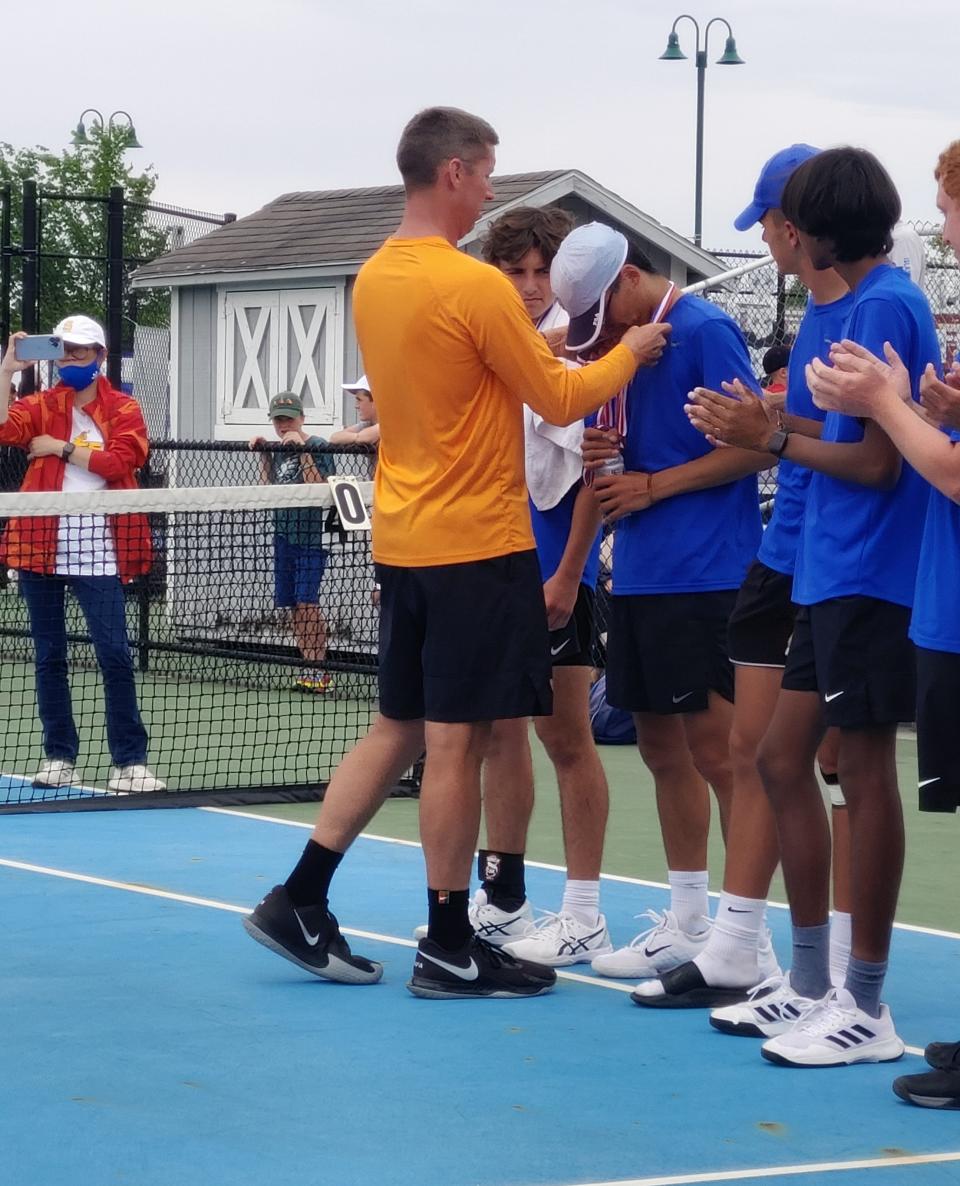 El entrenador de Olentangy Orange, Matt Rutherford, otorga al senior Zach Haar su medalla de segundo lugar del torneo estatal OTCA el domingo en New Albany.