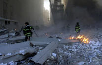 Firemen work around the World Trade Center after both towers collapsed in New York, in this September 11, 2001 file photograph. Eleven years after the Sept. 11, 2001, attacks, New Yorkers will mark the anniversary on Tuesday against a backdrop of health concerns for emergency workers and a feud over financing that has stopped construction of the $1 billion Ground Zero museum. REUTERS/Peter Morgan