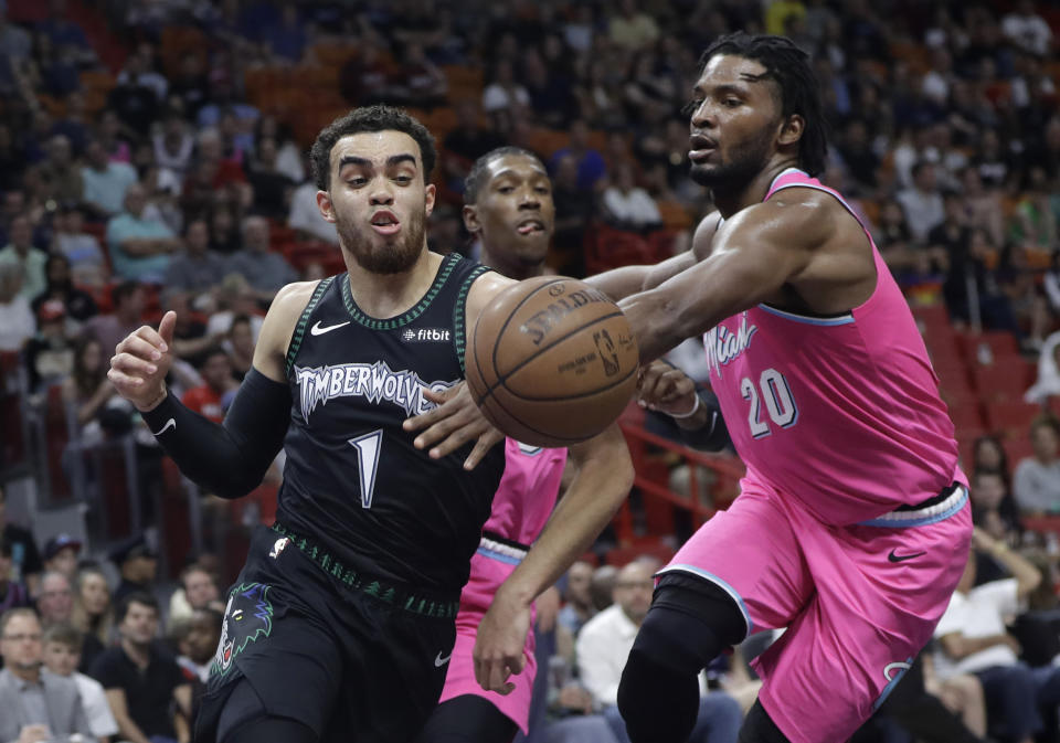 Miami Heat forward Justise Winslow (20) defends Minnesota Timberwolves guard Tyus Jones (1) during the first half of an NBA basketball game, Sunday, Dec. 30, 2018, in Miami. (AP Photo/Lynne Sladky)