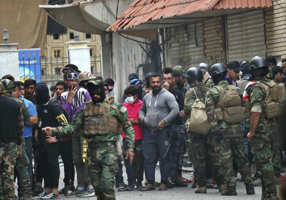 Anti-government protesters and security forces face-off on Rasheed Street, in Baghdad, Iraq, Sunday, Dec. 1, 2019. Iraq's parliament approved the resignation of Prime Minister Adel Abdul-Mahdi on Sunday, amid ongoing violence and anti-government demonstrations in the capital. (AP Photo/Hadi Mizban)