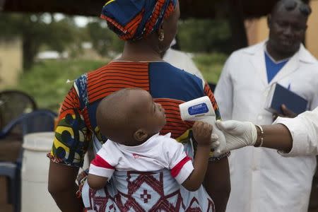 A health worker checks the temperature of a baby entering Mali from Guinea at the border in Kouremale, in this file photo taken on October 2, 2014. REUTERS/Joe Penney