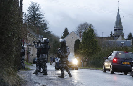 Members of the French GIPN intervention police forces secure a neighbourhood in Corcy, northeast of Paris January 8, 2015. REUTERS/Christian Hartmann