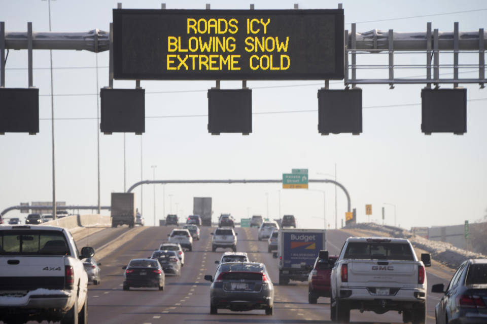 An electronic overhead sign warns motorists of weather-related dilemmas ahead on eastbound Interstate 70 near the Peoria Street exit Friday, Dec. 23, 2022, in Denver. Forecasters predict that warmer weather will be on tap for the week ahead. (AP Photo/David Zalubowski)