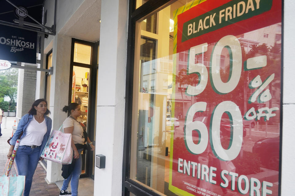 Shoppers looking for bargains enter an OshKosh children clothing store, Monday, Nov. 21, 2022, in Miami, Fla. Bargain hunting is back with full force heading into the holidays. But inflation is limiting how much of a deal consumers will be getting. (AP Photo/Marta Lavandier)