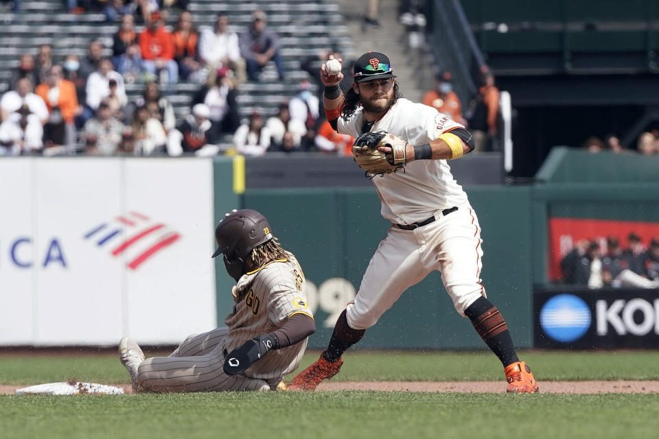 San Francisco Giants shortstop Brandon Crawford, right, throws to first base after forcing San Diego Padres' Fernando Tatis Jr. out at second base during the fifth inning of a baseball game in San Francisco, Thursday, Sept. 16, 2021. (AP Photo/Jeff Chiu)