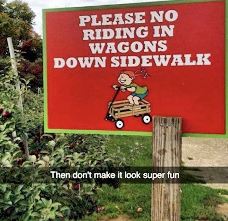 Sign with a child illustration saying, "Please no riding in wagons down sidewalk." Caption below: "Then don’t make it look super fun."