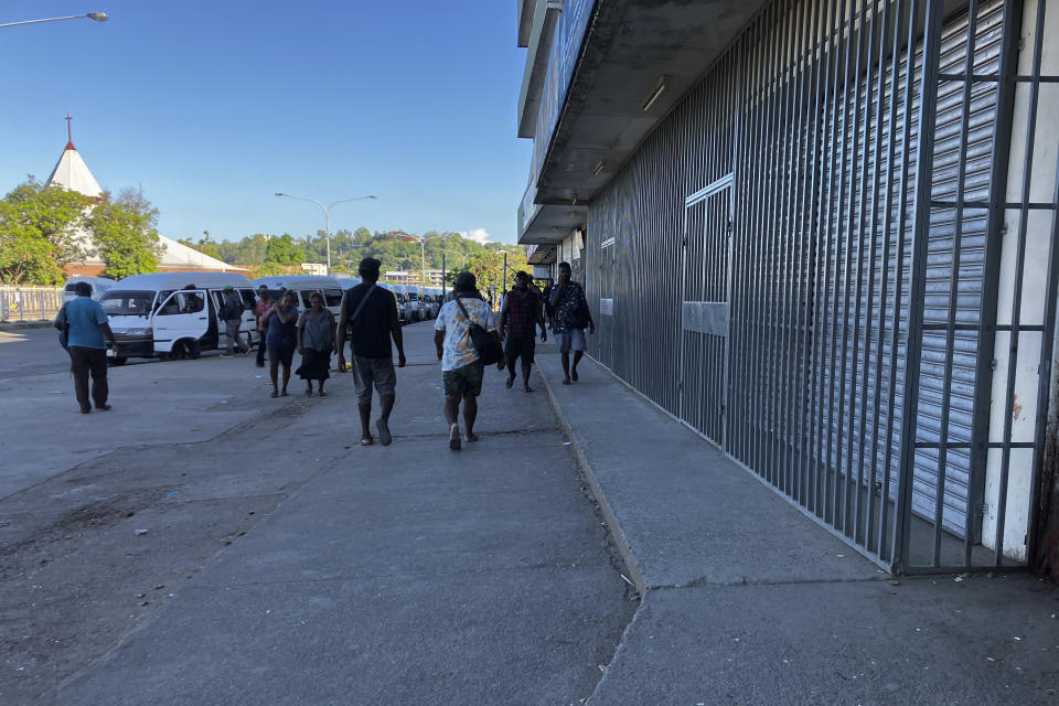 People gather outside shuttered stores in Honiara, Solomon Islands, following an earthquake, Tuesday, Nov. 22, 2022. A powerful earthquake jolted the Solomon Islands Tuesday afternoon, overturning tables and sending people racing for higher ground. (AP Photo/Charley Piringi)