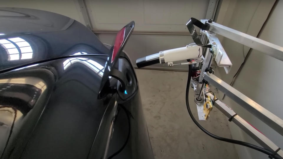 A Tesla home charger automatically inserting itself into a Tesla Model 3 vehicle.