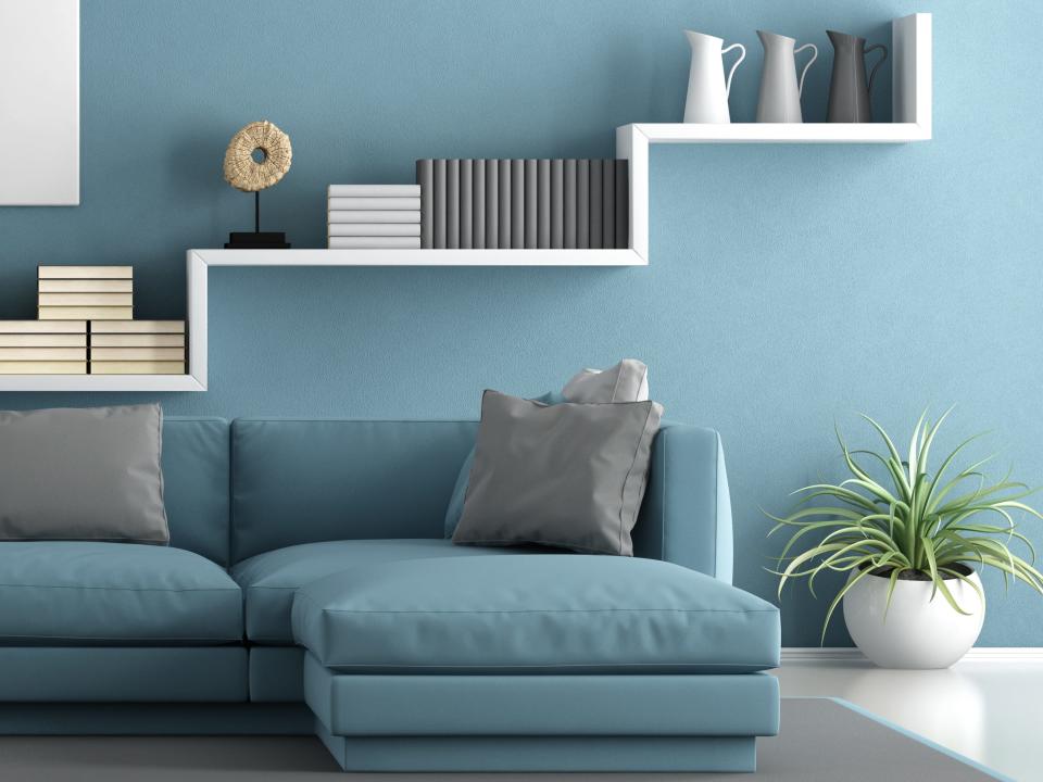 A blue-gray wall with a blue-gray couch