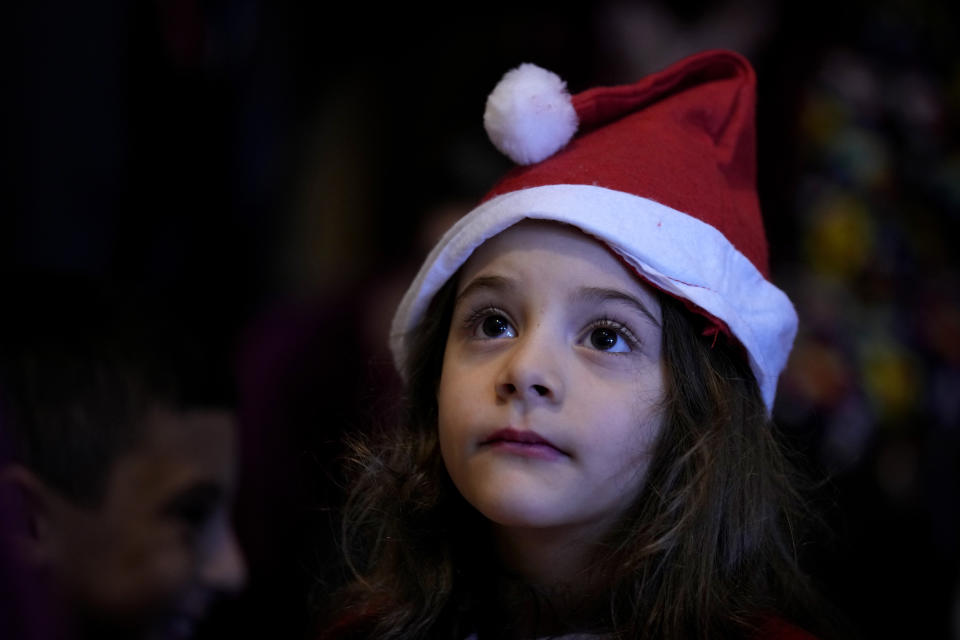 A girl waits to receive gifts during a gift distribution by the NGO Beit Atfal Assumoud at the only majority-Christian Palestinian refugee camp, in Dbayeh, north of Beirut, Lebanon, Friday, Dec. 23, 2022. Hundreds of thousands of Palestinians fled or were forced from their homes during the 1948 Mideast war over Israel's creation. Today, several million Palestinian refugees and their descendants are scattered across Jordan, Syria and Lebanon, as well as the West Bank and Gaza, lands Israel captured in 1967. (AP Photo/Bilal Hussein)