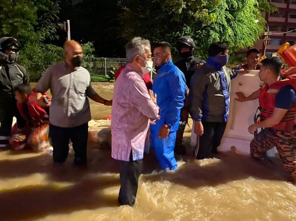 Yang di-Pertuan Agong Al-Sultan Abdullah Ri’ayatuddin Al-Mustafa Billah Shah stands in floodwaters as he checks on the flood situation in Kuala Lumpur. — Picture courtesy of Facebook/Istana Negara