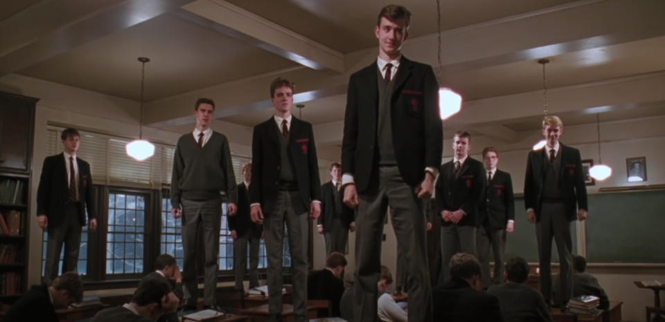 A group of students stand on their desks