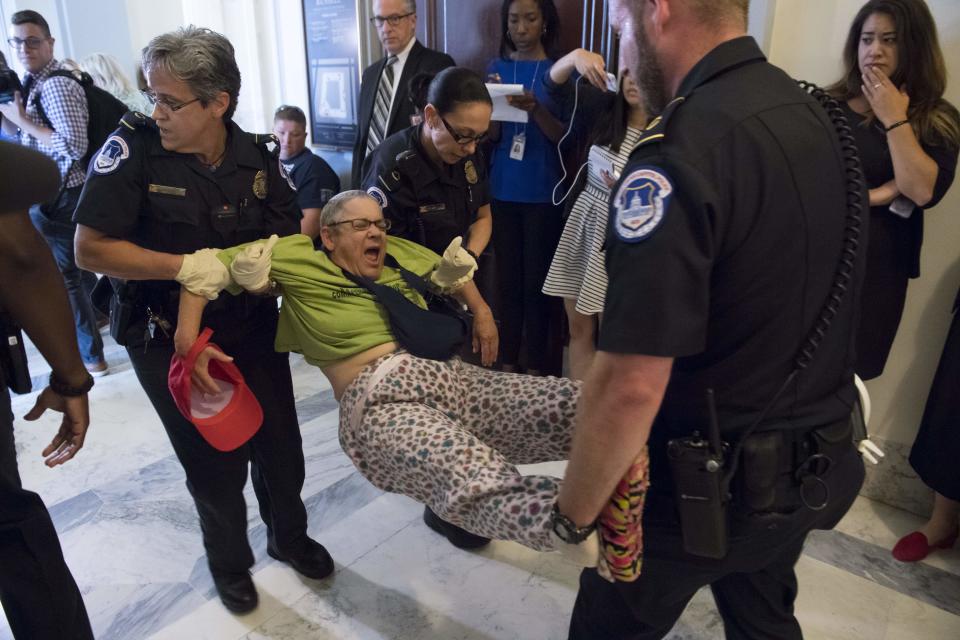 U.S. Capitol Police arrest a protester against the Senate Republicans' draft health care bill outside the office of Senate Majority Leader Mitch McConnell (R-Ky.) on June 22, 2017.