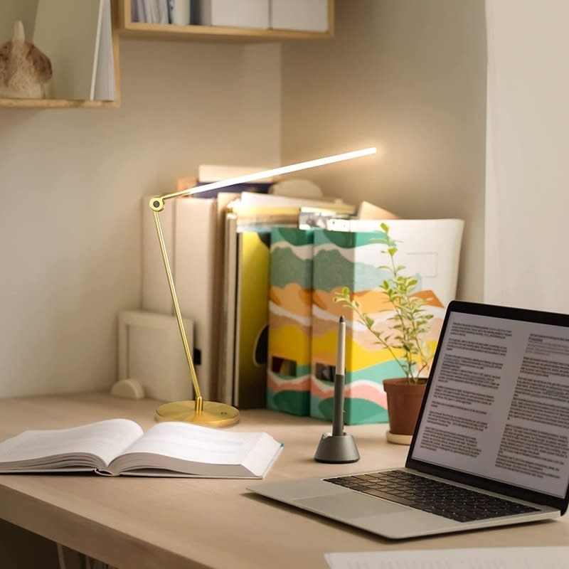 a gold desk lamp on a desk