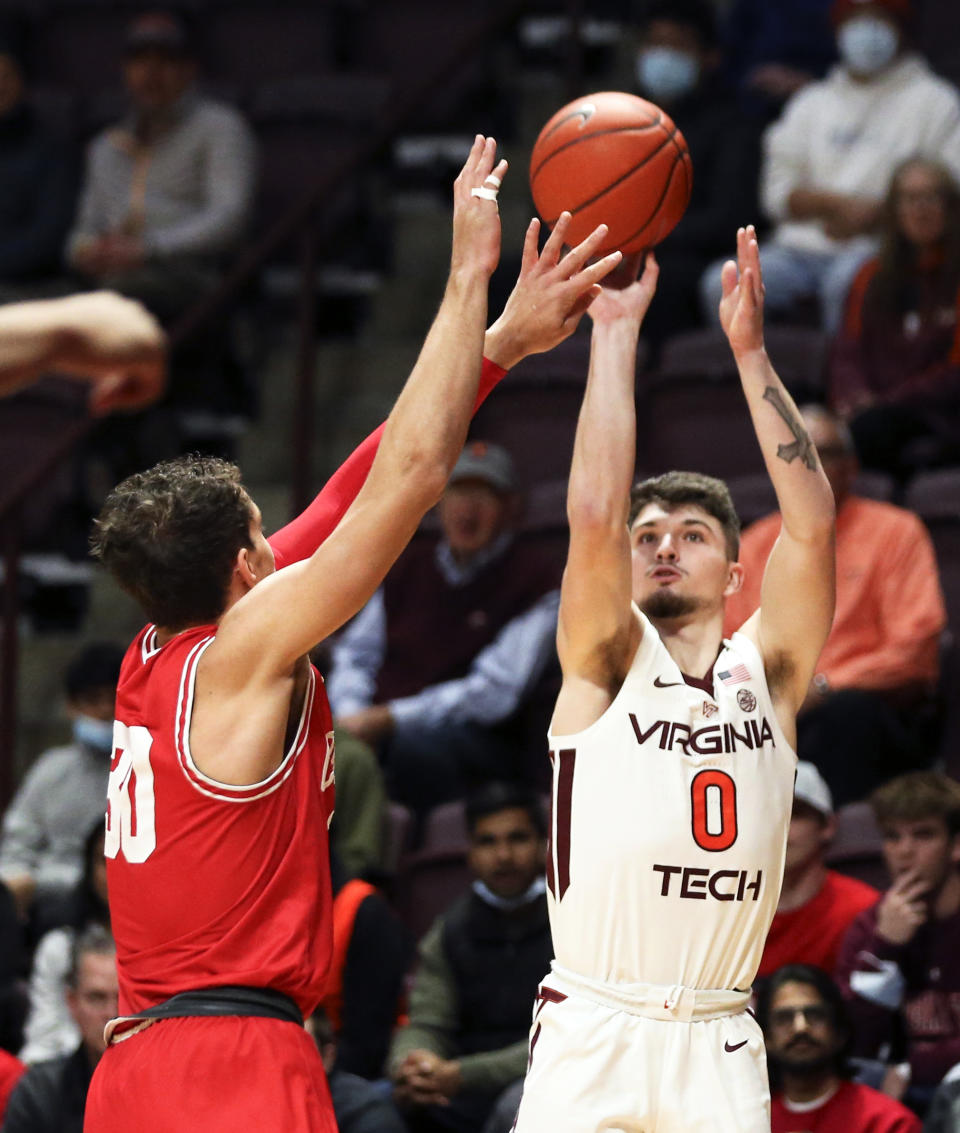 Virginia Tech's Hunter Cattoor (0) shoots a 3-point basket over Cornell's Chris Manon (30) during the first half of an NCAA college basketball game Wednesday, Dec. 8 2021, in Blacksburg, Va. (Matt Gentry/The Roanoke Times via AP)