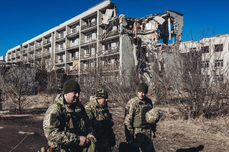 Varios soldados caminan por la ciudad en ruinas tras un ataque en Marinka, Ucrania