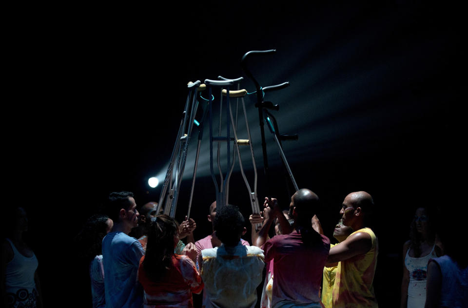 In this Dec. 4, 2018 photo, dancers hold canes and crutches in unison as they perform in the contemporary dance production Ubuntu, at the Teresa Carreno Theater in Caracas, Venezuela. Caracas based AM Danza dance troupe works with 50 young Venezuelans who are pursuing their passion for dance despite limitations like broken spines, cerebral palsy or blindness. (AP Photo/Fernando Llano)