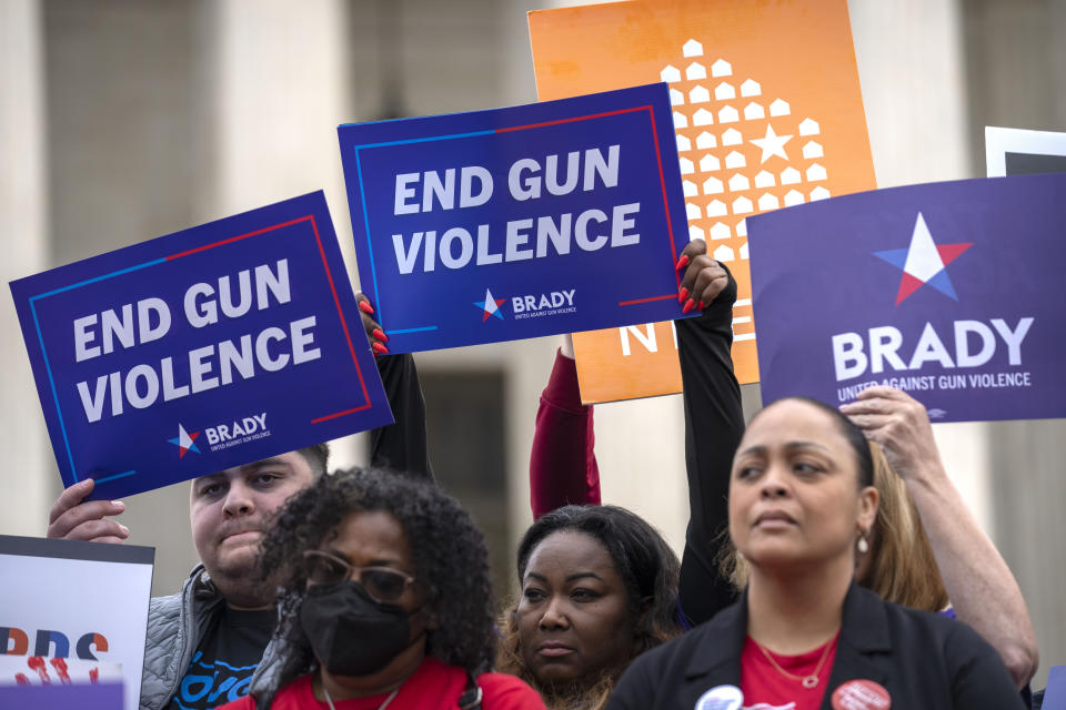 Demonstrators hold signs reading "End Gun Violence" at the Supreme Court on Tuesday, Nov. 7, 2023, in Washington. The Supreme Court is taking up a challenge to a federal law that prohibits people from having guns if they are under a court order to stay away from their spouse, partner or other family members. (AP Photo/Mark Schiefelbein)