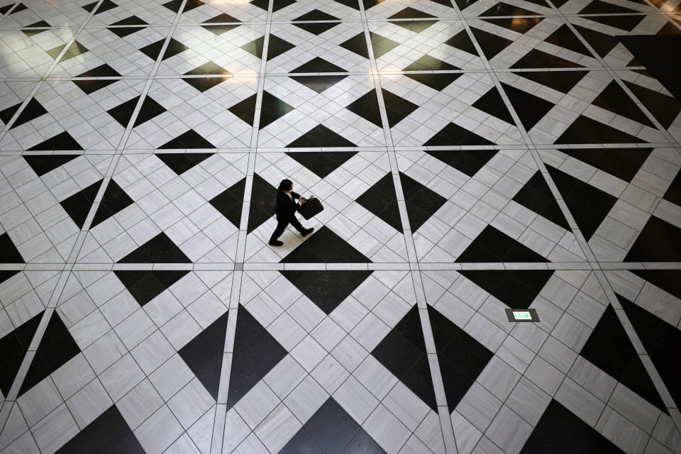 A man wearing a face mask to help curb the spread of the coronavirus walks at a building in Tokyo, Thursday, Aug. 27, 2020. (AP Photo/Eugene Hoshiko)