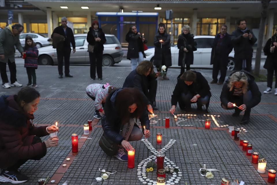 People light candles, in memory of the trains collision victims, outside the train station of Larissa city, about 355 kilometres (222 miles) north of Athens, Greece, Thursday, March 2, 2023. Emergency crews inched through the mangled remains of passenger carriages in their search for the dead from Tuesday night's head-on collision, which has left dozens passengers dead in Greece's worst recorded rail accident. (AP Photo/Vaggelis Kousioras)