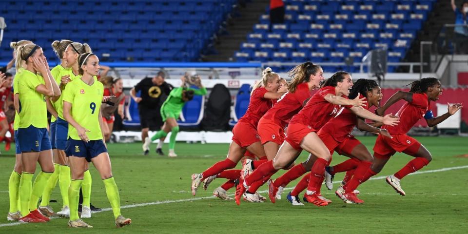 Sweden's women's soccer team looks on as Canada's team celebrates winning the gold medal