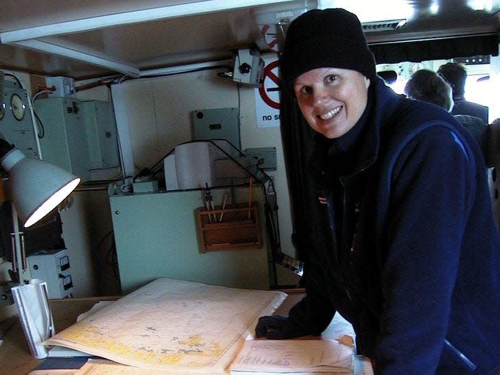 Jill Heinerth leans over a table and smiles at the camera