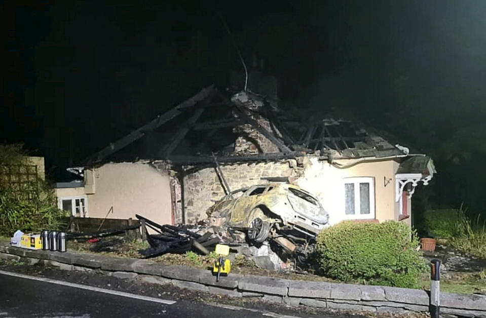 Dramatic picture shows car which crashed into a house on the A38 in Cornwall before bursting into flames. See SWNS story SWPLcrash; The crash took place in the early hours of this morning 19/10/2020