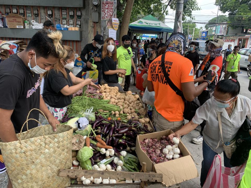 Volunteers and recipients are seen at the Maginhawa community pantry food donation site in Quezon City, outside Manila, Philippines, April 26, 2021. / Credit: CBS/Barnaby Lo