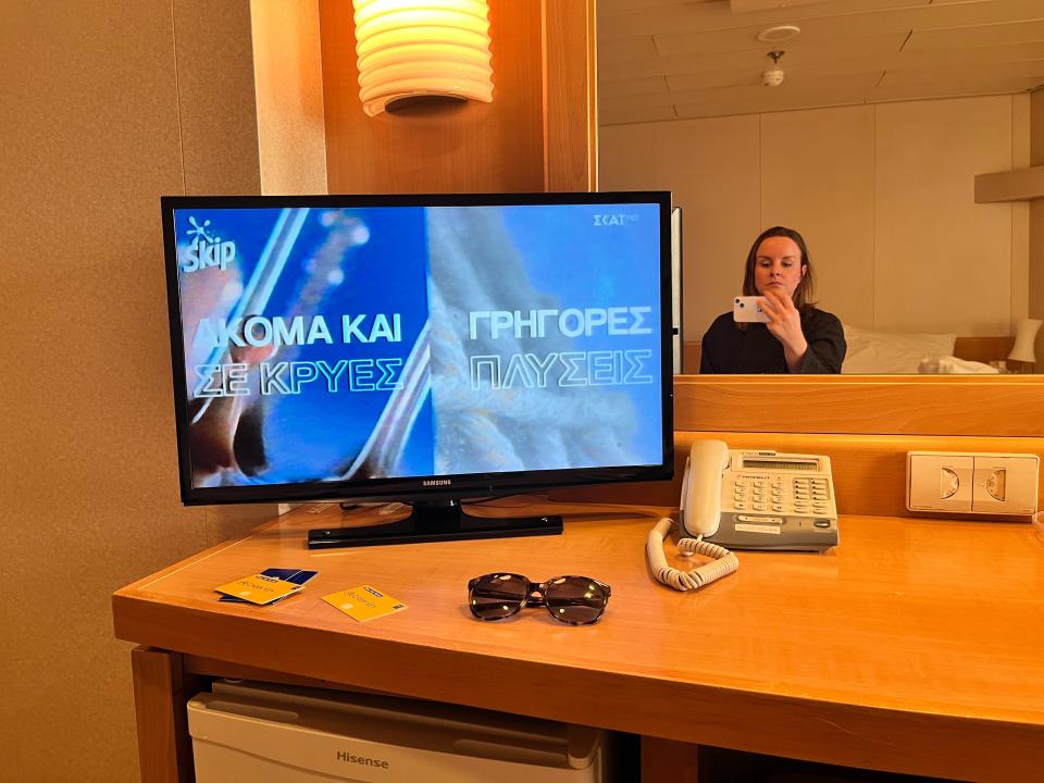 katie taking a mirror selfie next to a tv in a cabin on a ferry