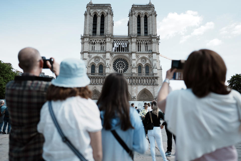 People take snapshot of the Notre Dame Carthedral, in Paris, Friday, April 15, 2022. Three years ago fire swept across the top of the Notre Dame Cathedral as the soaring Paris landmark underwent renovations; the blaze collapsed the cathedral's spire and spread to one of its landmark rectangular towers, but fire officials said the church's structure had been saved. (AP Photo/Thibault Camus)